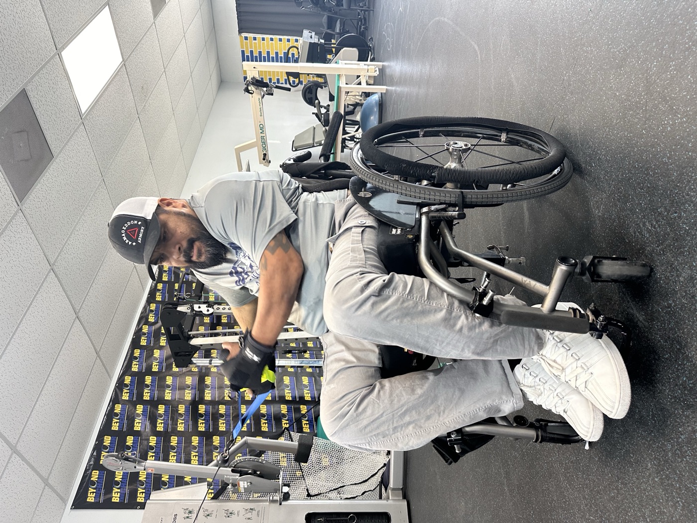 A member in a wheelchair does a cable row.